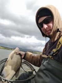 a man holding a fish on a boat