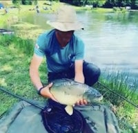 a man in a hat is holding up a fish